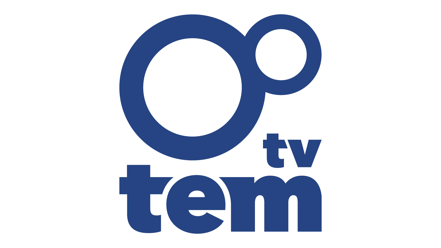 Logo da emissora TV TEM, em estilo minimalista e moderno. O logotipo é composto por dois círculos azuis: um grande à esquerda e outro menor, posicionado à direita e um pouco acima, como se estivesse “orbitando” o maior. À direita dos círculos está a palavra “tem” em letras minúsculas e negrito, também na cor azul. Acima da letra “m”, em tamanho reduzido, aparece a sigla “tv”, também em azul. O fundo da imagem é transparente.