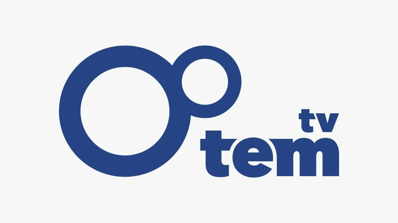 Logo da emissora TV TEM, em estilo minimalista e moderno. O logotipo é composto por dois círculos azuis: um grande à esquerda e outro menor, posicionado à direita e um pouco acima, como se estivesse “orbitando” o maior. À direita dos círculos está a palavra “tem” em letras minúsculas e negrito, também na cor azul. Acima da letra “m”, em tamanho reduzido, aparece a sigla “tv”, também em azul. O fundo da imagem é transparente.