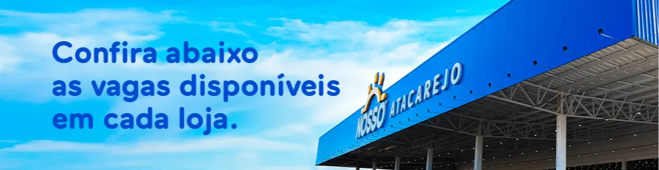 Fachada externa de uma loja do Nosso Atacarejo, com cobertura azul e o logo da marca visível na parte superior. No céu azul ao fundo, aparece um texto escrito: “Confira abaixo as vagas disponíveis em cada loja.