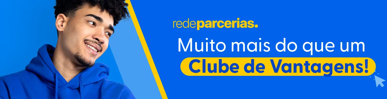 Banner da página de carreiras da Rede Parcerias. A imagem tem um fundo azul vibrante. No lado esquerdo, há a foto de um jovem sorrindo, que veste um moletom também azul. Ele olha para o lado direito, onde está o texto principal, que diz: "Muito mais do que um Clube de Vantagens!". A frase "Clube de Vantagens!" está em letras amarelas e destacada dentro de uma faixa amarela, como se tivesse sido grifada com um marcador. Acima do texto, está o logo "redeparcerias." e um pequeno ícone de cursor de mouse aponta para a frase em destaque.