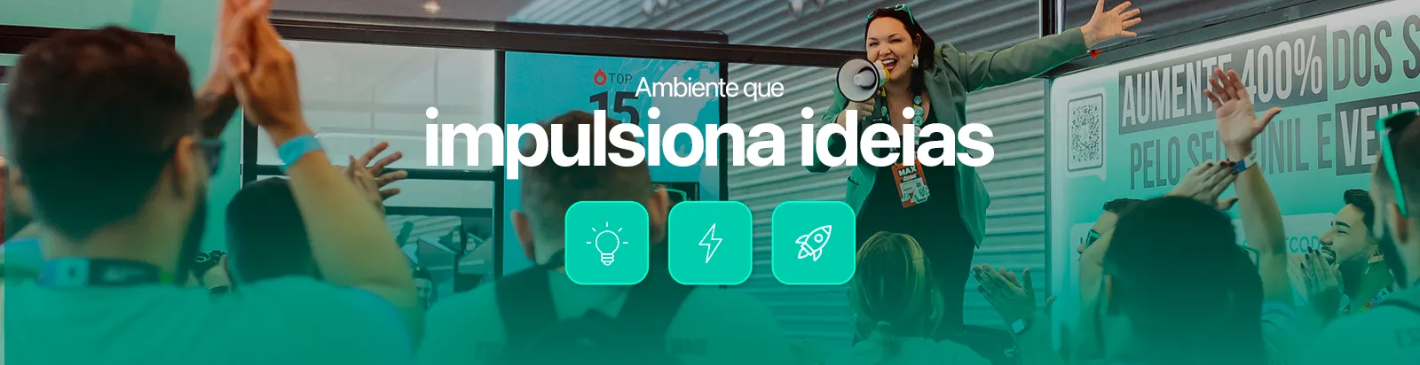Dentro de um stand de um grande evento, a CEO da empresa está falando com entusiasmo ao megafone em cima de uma bancada para os de colaboradores da LigueLead, que aplaudem com as mãos levantadas. A frase sobreposta diz:
“Ambiente que impulsiona ideias.”

Descrição de acessibilidade:
Foto de uma integrante da LigueLead discursando para o time, com energia e empolgação. O público aplaude e interage com entusiasmo. A imagem comunica um ambiente inspirador e focado em crescimento e inovação.