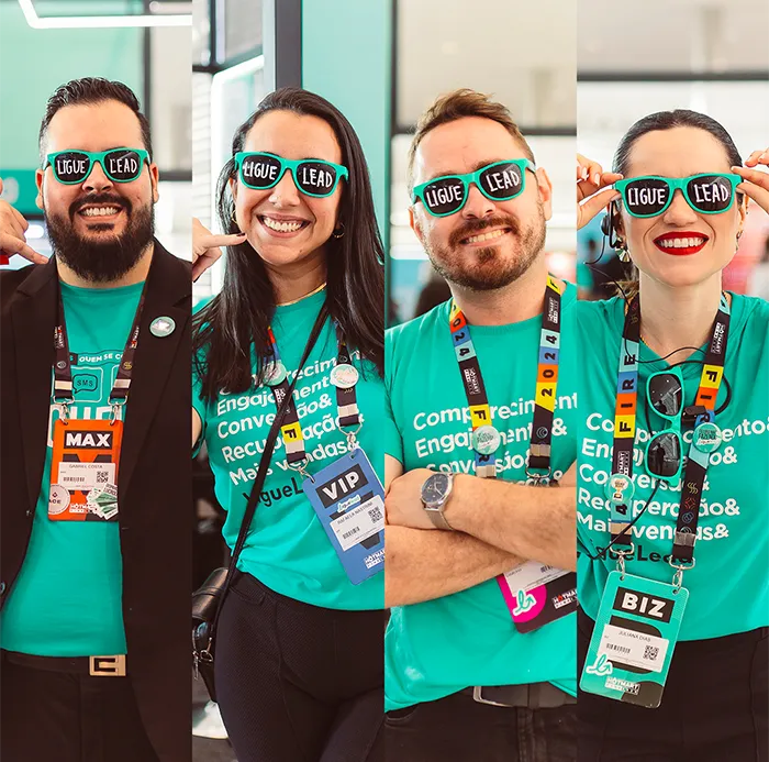 Imagem dividida em quatro colunas, com quatro colaboradores da LigueLead sorrindo e usando óculos escuros personalizados com a frase “LIGUE LEAD” escrita nas lentes. Todos vestem camisetas verde-turquesa da empresa, com palavras como “Engajamento”, “Conversão” e “Recuperação”. Estão com crachás de eventos pendurados no pescoço e transmitem alegria e orgulho de fazer parte da marca.