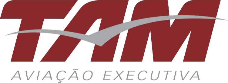 O logo apresenta o nome "TAM" em letras maiúsculas, na cor vermelha, com uma linha curva em cinza claro que atravessa as letras, simulando o movimento de um avião em voo. Abaixo do nome "TAM", em letras menores e cinza claro, está escrito "AVIAÇÃO EXECUTIVA". O design evoca dinamismo e profissionalismo, associado ao setor de aviação.